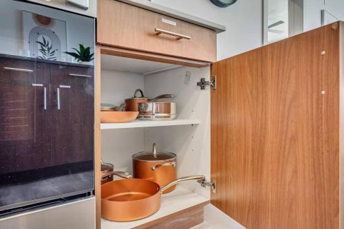 a kitchen with wooden cabinets and pots and pans at Upscale 2BR w Pool Gym & Near Hill AFB in Clearfield