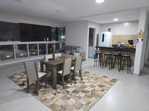 una sala da pranzo e una cucina con tavolo e sedie di Apartamento Beira Mar 3 Suites a Anchieta
