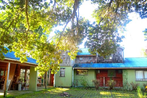 a house with a tree in front of it at Casa Nelson Rural Puerto Montt in Puerto Montt