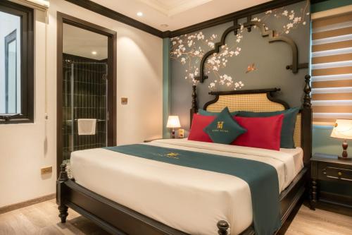 a bedroom with a large bed with red pillows at Hanoi Bliss Hotel in Hanoi