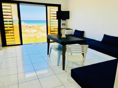 a living room with a table and chairs and the ocean at Casa del Mar Residences in Kelibia