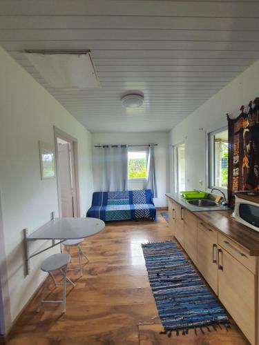 a kitchen and living room with a table and a couch at Bungalow B1 in Kumak