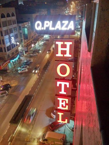 a sign for a pizza restaurant on the side of a building at Queen Plaza Hotel in Hebron