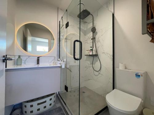 a bathroom with a shower with a toilet and a sink at The Gilded Cross - Luxury CBD 3 Bedrooms in Christchurch