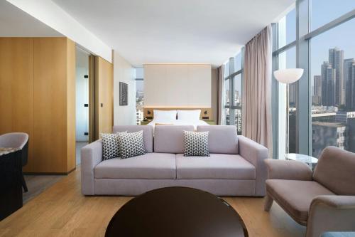 a living room with a couch and a bed at The Mercury Garden Shenzhen Nanshan, A Tribute Portfolio Hotel in Shenzhen
