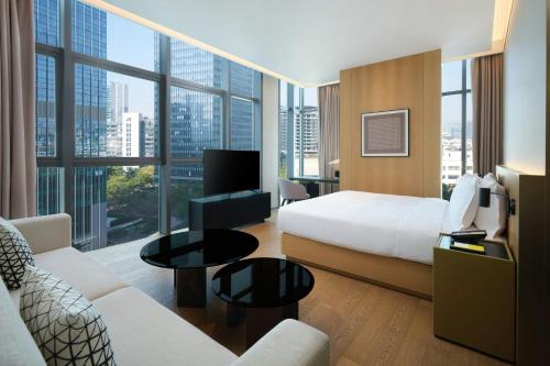 a hotel room with a bed and a large window at The Mercury Garden Shenzhen Nanshan, A Tribute Portfolio Hotel in Shenzhen