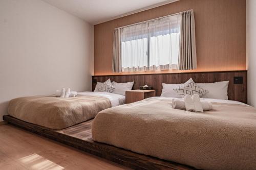 two beds sitting next to each other in a bedroom at Apartment Hotel 11 Villa Tengachaya in Osaka