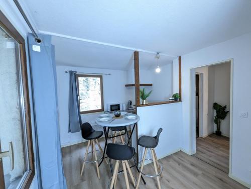 - une petite table dans une chambre avec une fenêtre et des chaises dans l'établissement Le Nanty - Appartement Duplex Cosy et Central- Accès Gare et Centre Ville, à Poitiers