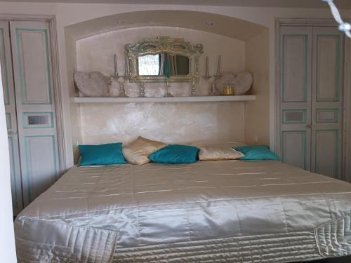 a bed with blue pillows in a bedroom at Village House in France with Private Pool in Bagnols-en-Forêt