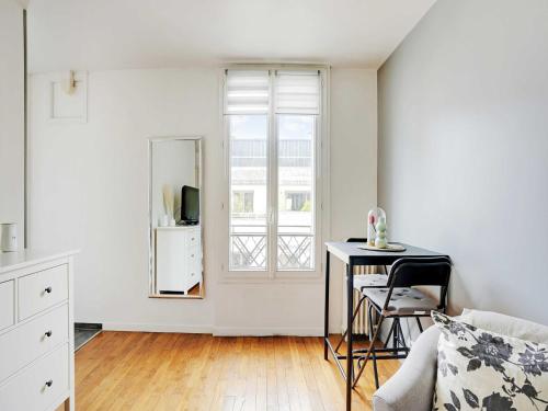 Una sala de estar con una mesa y una ventana. en Fully equipped modern studio -2P- Levallois-Perret, en Levallois-Perret