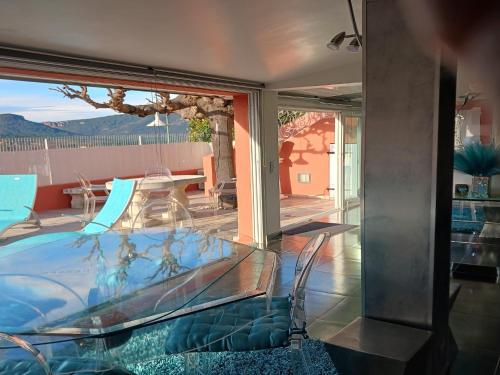 a room with a glass table and a view of a patio at Village House in France with Private Pool in Bagnols-en-Forêt