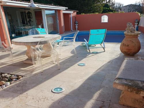 a patio with a table and chairs on a patio at Village House in France with Private Pool in Bagnols-en-Forêt