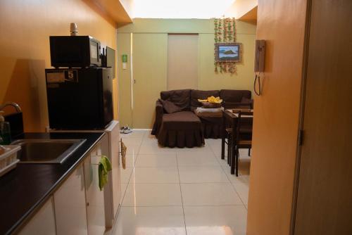 a kitchen and dining room with a couch and a table at Wind Residences For Rent - Luiice in Tagaytay