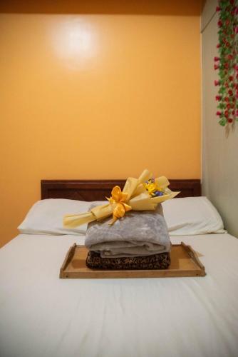 a tray with flowers on top of a bed at Wind Residences For Rent - Luiice in Tagaytay