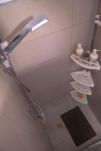 a shower head in a bathroom with a shelf at Wind Residences For Rent - Luiice in Tagaytay