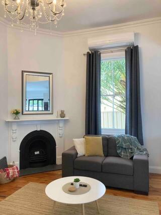 a living room with a couch and a table at Newly renovated, Kennedy Cottage - close to CBD in Bendigo