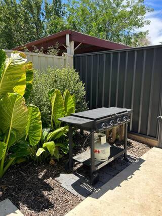 a picnic table in a garden next to a fence at Newly renovated, Kennedy Cottage - close to CBD in Bendigo