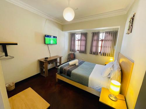 pokój hotelowy z łóżkiem i telewizorem w obiekcie TATA Hotel Boutique w Cuzco