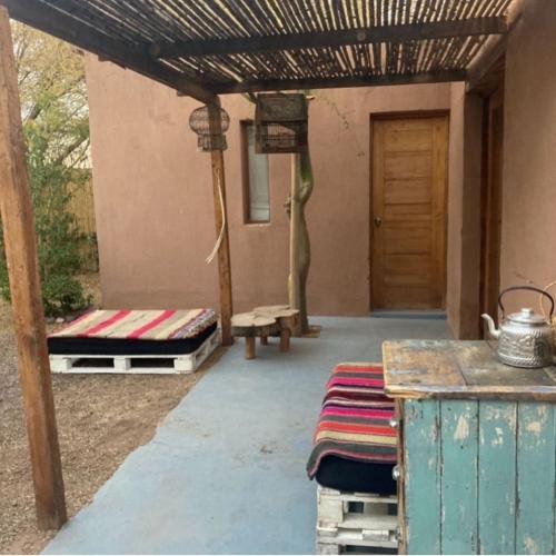 a patio with two beds and a wooden door at Casa Luna in San Pedro de Atacama