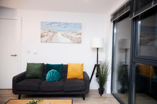 a living room with a couch with colorful pillows at Luxury 2 Bedroom and bathroom in Central Manchester With Balcony in Manchester
