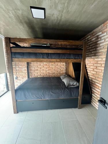 a bedroom with a bunk bed in a brick wall at Casa con Alberca privada en Cuernavaca in Ahuatepec