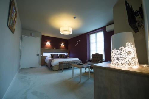 a hotel room with a bed and a desk in a room at Chateau du Clos de la Ribaudiere - Teritoria in Chasseneuil-du-Poitou