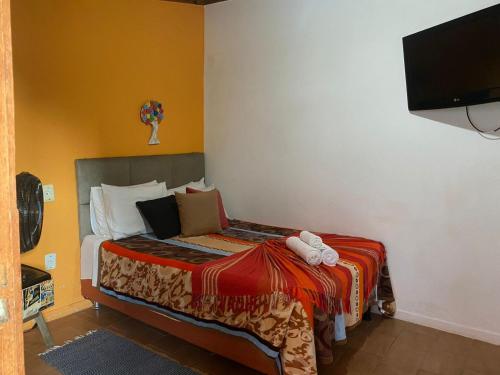 a bedroom with a bed with a red blanket on it at Pousada Princesa da Serra in Serra do Cipo