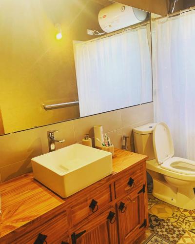 a bathroom with a sink and a toilet and a mirror at Casa de Mar y Barro in Maldonado