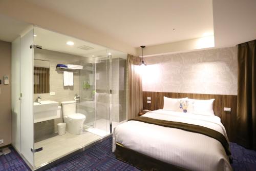 a bedroom with a bed and a bathroom with a shower at Ark Hotel - Changan Fuxing方舟商業股份有限公司 in Taipei