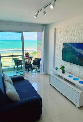 a living room with a flat screen tv and a couch at Aptº. Beira Mar com Vista Mar. in Recife