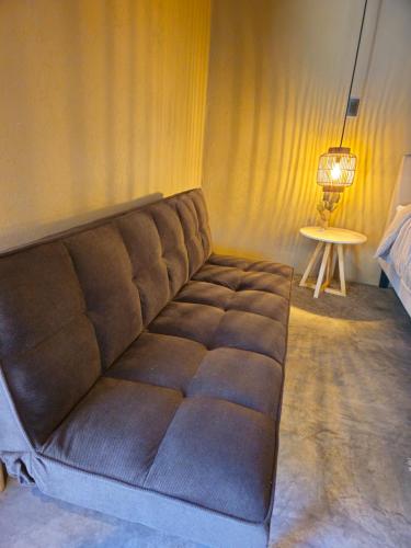 a brown couch in a room with a table at Hacienda Tierra de Fuego Pacaya in Escuintla