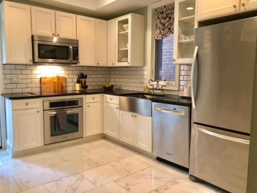 una cucina con armadietti bianchi ed elettrodomestici in acciaio inossidabile di Modern Victorian Elegance - 5 Blocks to The US Capitol a Washington