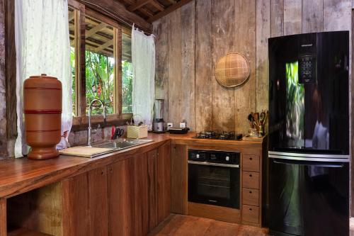 a kitchen with a counter with a stove and a refrigerator at Casa BEE Trancoso in Trancoso