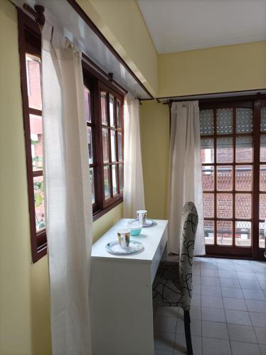 a room with a table and a chair and windows at Kairos in Buenos Aires