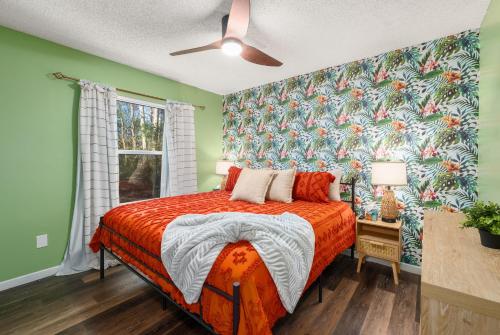 ein Schlafzimmer mit einem Bett mit geblümter Tapete in der Unterkunft Havana Hideaway 3BR Home with Private Pool and Dedicated Office in St. Augustine