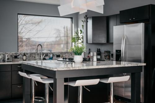 une cuisine avec un grand îlot de cuisine avec tabourets dans l'établissement Vitalia Fantastic 1BR Studio Downtown, à Traverse City