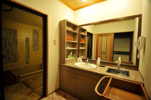a bathroom with a sink and a mirror at Nisshokan Bettei Koyotei in Nagasaki