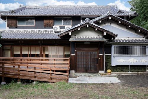 a house with a wooden fence in front of it at 古民家の郷 かぐや姫 in Tondabayashi