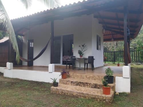 a white house with a patio with a table at Casa Mariposa Puertolindo in Garrote