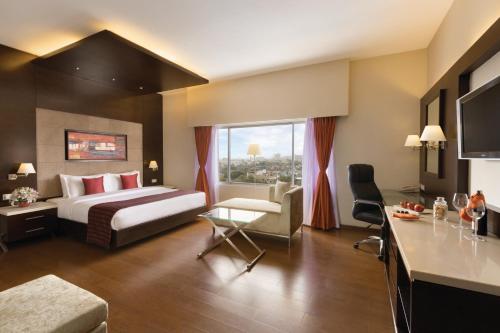 a large hotel room with a bed and a desk at Ramada by Wyndham Chennai Egmore in Chennai