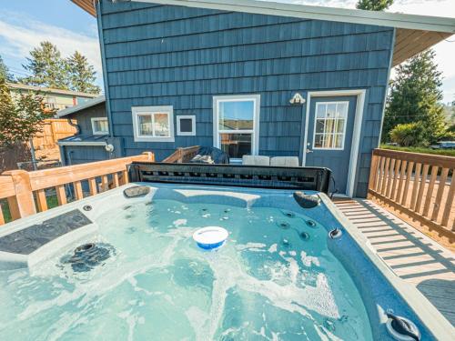 a house with a hot tub on a deck at Moon Over The Mills in Neotsu
