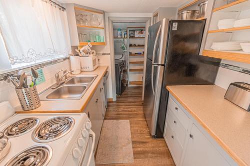 a kitchen with a sink and a refrigerator at Moon Over The Mills in Neotsu