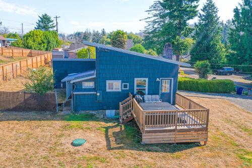 a blue house with a deck in a yard at Moon Over The Mills in Neotsu
