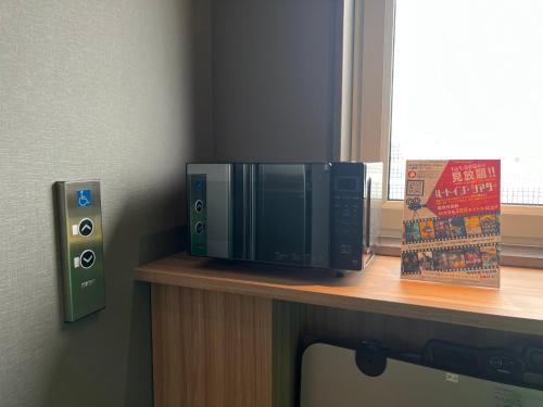 a microwave sitting on top of a desk at Hotel Route Inn Suzaka in Suzaka