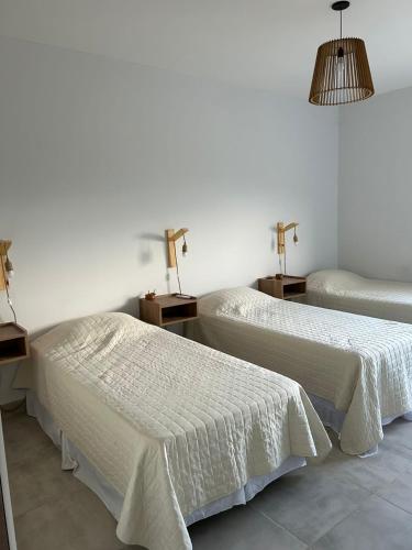 two beds in a room with two lamps on tables at Cerros de Cafayate, Casa Nº2 in Cafayate