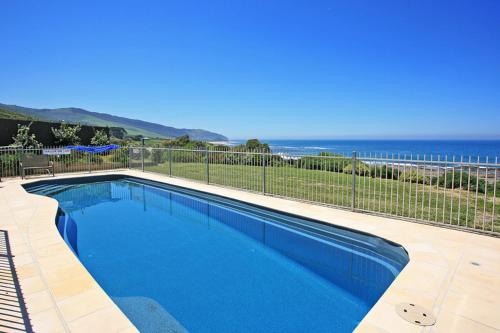 a blue swimming pool with the ocean in the background at 12 Whitecrest Great Ocean Road Resort - Ocean Views in Wongarra