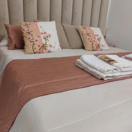 Una cama con almohadas y toallas encima. en Borgo La Chiusa, en Cinisi