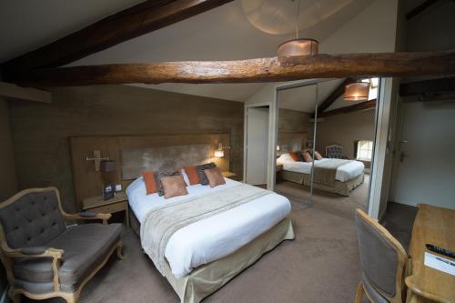 a bedroom with a large bed and a chair at Chateau du Clos de la Ribaudiere - Teritoria in Chasseneuil-du-Poitou
