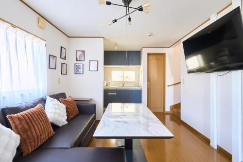 a living room with a couch and a table at JR ChuoLine Aasagaya station 5min,Shinjuku 8min Max15pp 2WC in Tokyo