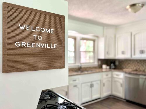 a kitchen with a welcome to greenville sign on the wall at New Modern Lux Large Home 10MIN Downtown Sleeps 12 in Taylors